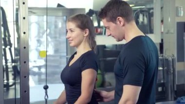 Genç Yetişkin kız onu kişisel antrenörü tarafından liderliğindeki simülatörleri bir egzersiz yapıyor. 4k, ağır çekim