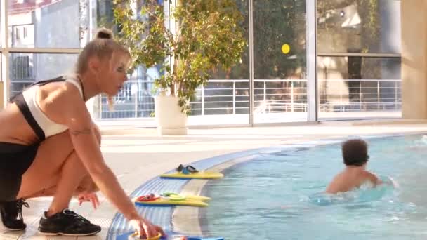 La chica, el entrenador de natación, lleva a cabo el entrenamiento en la piscina con los niños. 4k, cámara lenta — Vídeo de stock