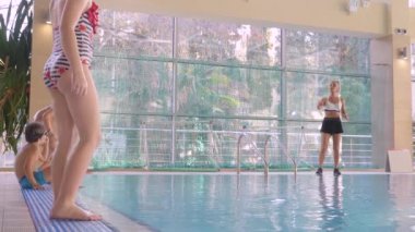 Kız, yüzme Koç, bir eğitimle havuzda çocuklar yapar. 4k, ağır çekim