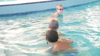 Yüzme antrenörü bir eğitimle havuzda çocuklar yapar. 4k, ağır çekim