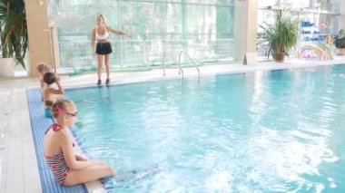 Kız, yüzme Koç, bir eğitimle havuzda çocuklar yapar. 4k, ağır çekim