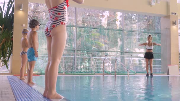 La fille, l'entraîneur de natation, effectue une formation dans la piscine avec les enfants. 4k, au ralenti — Video