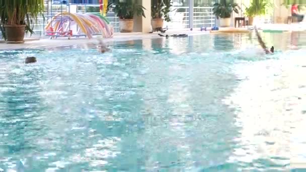 Niños nadan en la piscina 4k, tiro en cámara lenta — Vídeo de stock