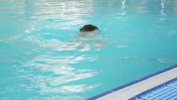 Děti plavat v bazénu, dělá roll ve vodě 4k, zpomaluje — Stock video