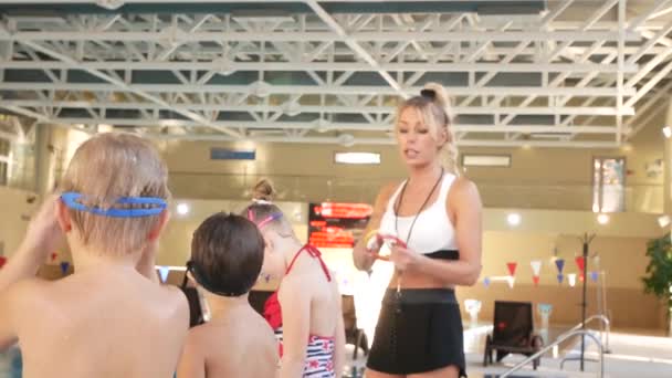 La chica, el entrenador de natación, lleva a cabo el entrenamiento en la piscina con los niños. 4k, cámara lenta — Vídeos de Stock