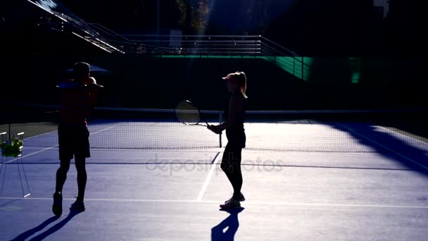 Spieler wärmen sich vor einer Partie Tennis auf. ältere Männer und Frauen beim Tennisspielen. 4k, Silhouetten — Stockvideo