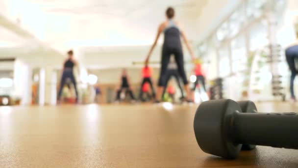 Clase de fitness en el gimnasio. las mujeres se dedican al entrenamiento de poder. entrenamiento en grupo. Borroso. 4k, personas irreconocibles — Vídeo de stock