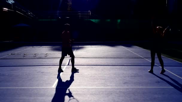 Spieler wärmen sich vor einer Partie Tennis auf. ältere Männer und Frauen beim Tennisspielen. 4k, Silhouetten — Stockvideo