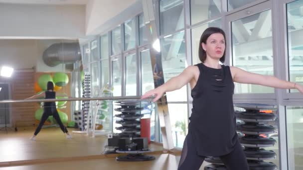 Bir kadın eğitmen portresi. yakın çekim. spor salonunda, 4 k germe egzersizleri fitness eğitmeni gösterir. — Stok video
