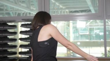 Bir kadın eğitmen portresi. yakın çekim. spor salonunda, 4 k germe egzersizleri fitness eğitmeni gösterir.