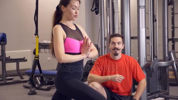 Fiatal felnőtt lány csinál egy edzés a neki személyi edzővel vezette szimulátorok. 4k, lassú mozgás — Stock videók