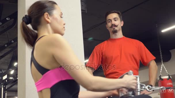 Giovane ragazza adulta che fa un allenamento sui simulatori guidati dal suo personal trainer. 4k, rallentatore — Video Stock