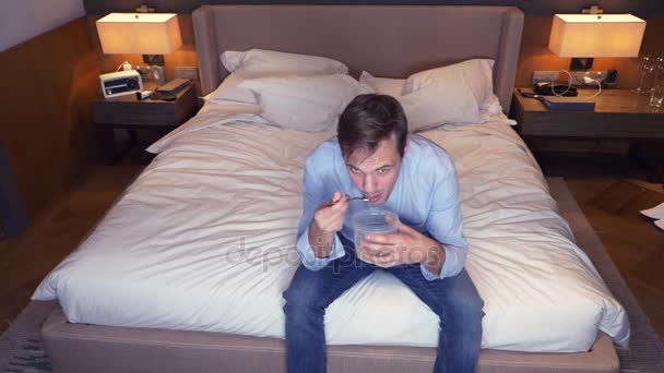 Αρσενικό επιχειρηματίας τρώει τροφές από ένα κοντέινερ. κάθεται μπροστά από την τηλεόραση. 4 k — Αρχείο Βίντεο