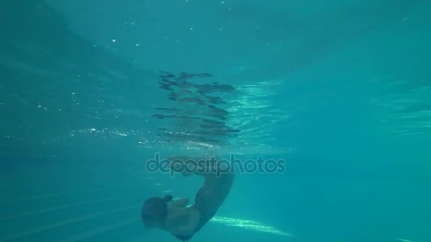 Barn simma i poolen, flickan gör en rulle i vattnet 4k fotografering under vattnet — Stockvideo