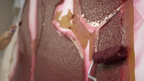 Mão pintando a parede com rolo de tinta no estêncil, de perto. 4k — Vídeo de Stock
