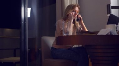 bir masada bir dizüstü bilgisayarda bir otel odasında geceleri çalışan kadın. 4 k. düştüğü uykuda işyerinde, onu bir telefon görüşmesi uyanır ..