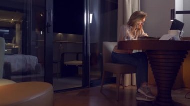 bir masada bir dizüstü bilgisayarda bir otel odasında geceleri çalışan kadın. 4 işyeri, uykuya düştüğü k. esnemek.