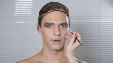 Travesti makyaj. genç bir adam kendine bir transseksüel mencup hazırlar. 4k, ağır çekim.