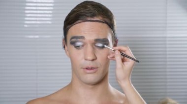 Travesti makyaj. genç bir adam kendine bir transseksüel mencup hazırlar. 4k, ağır çekim.