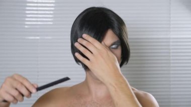 Travesti makyaj. genç bir adam kendine bir transseksüel mencup hazırlar. 4k, ağır çekim.