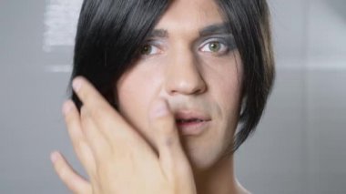 Travesti makyaj. genç bir adam kendine bir transseksüel mencup hazırlar. 4k, ağır çekim.