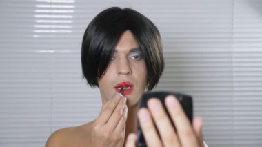Travesti makyaj. genç bir adam kendine bir transseksüel mencup hazırlar. 4k, ağır çekim.