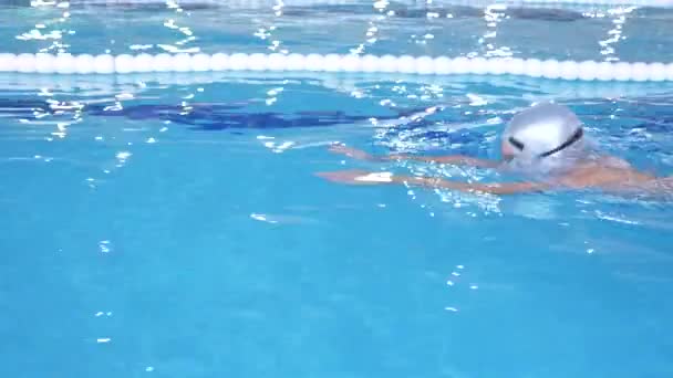 Chico, un atleta se zambulle desde la torre en una piscina deportiva. 4k, cámara lenta, primer plano — Vídeos de Stock