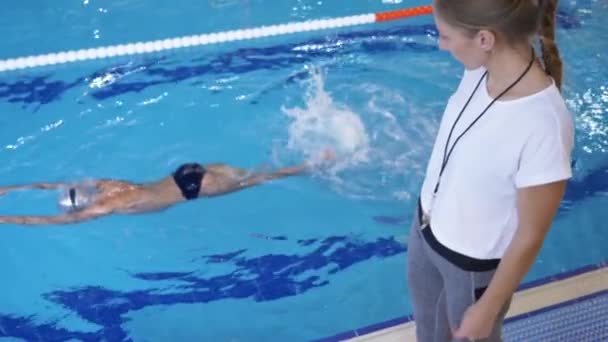 Allenamento degli atleti di nuoto. L'allenatore insegna al ragazzo a tuffarsi nella piscina sportiva. 4k, rallentatore — Video Stock