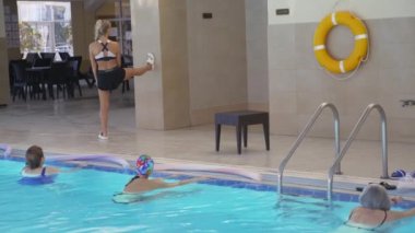 Yüzme havuzunda kadın su jimnastiği eğitmeni. 4K