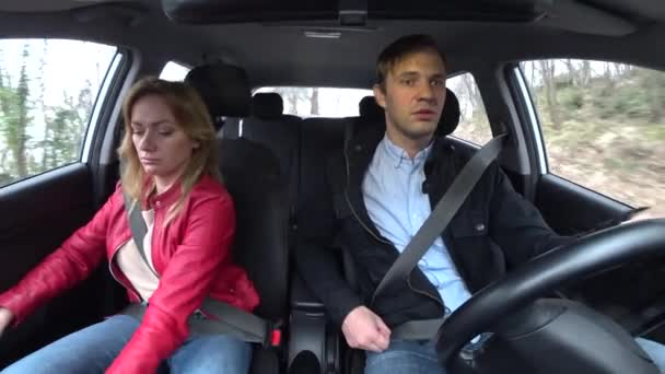 Man and woman ride in a car in an unfamiliar area, fastened with seat belts, 4k — Stock Video