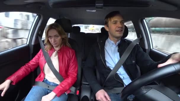 Homem e mulher passeio em um carro em uma área desconhecida, apertado com cintos de segurança, 4k — Vídeo de Stock