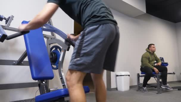 4k, una persona divertente è impegnata in palestra sui simulatori senza un allenatore. non fa gli esercizi correttamente. mostro in palestra — Video Stock