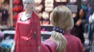 Depodaki cam vitrin, arayan bir kadın. 4k, arka plan bulanıklık. iç çamaşırı Dükkanı