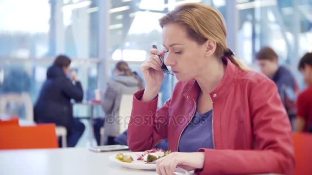 Uma mulher comendo legumes grelhados e shish kebab em um café. 4K, desfoca o fundo. espaço para cópia — Vídeo de Stock