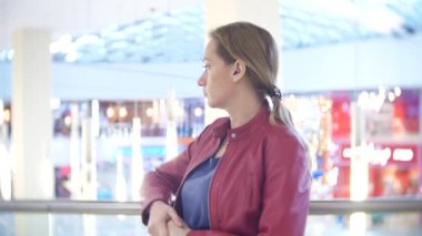 Bir kadın bir mağazada duruyor. 4k, arka plan bulanıklık.