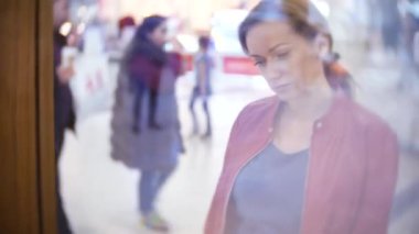 Depodaki cam vitrin, arayan bir kadın. 4k, arka plan bulanıklık.