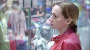 Depodaki cam vitrin, arayan bir kadın. 4k, arka plan bulanıklık.