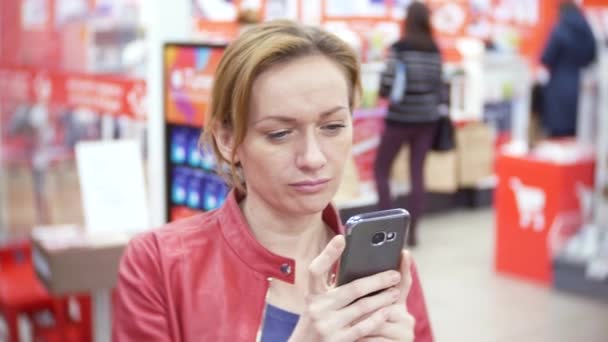 购物, 技术, 销售, 消费主义和人的概念-妇女与智能手机在超市。4k、背景模糊 — 图库视频影像