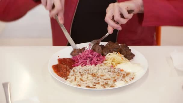 Mujer comiendo arroz, verduras y shish kebab en un café. 4k, borra el fondo. espacio para copiar — Vídeos de Stock