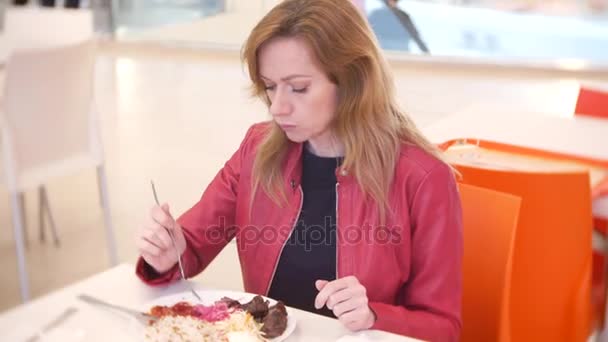 Donna mangiare riso, verdure e shish kebab in un caffè. 4k, sfoca lo sfondo. spazio per la copia — Video Stock
