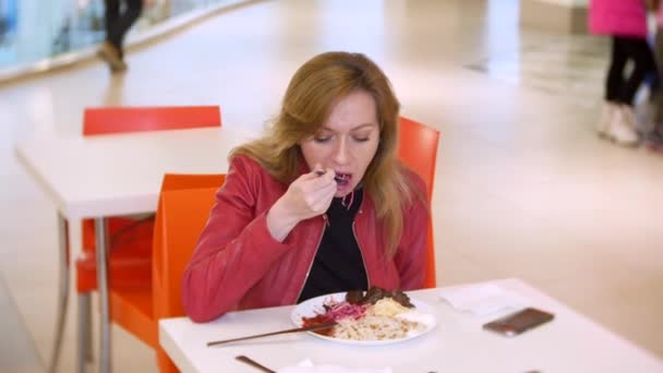 Mulher comendo arroz, legumes e kebab shish em um café. 4K, desfoca o fundo. espaço para cópia — Vídeo de Stock