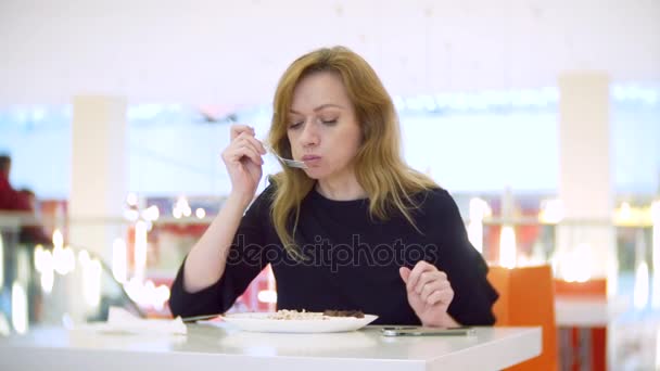 Femme mangeant du riz, des légumes et du shish kebab dans un café. 4k, brouille le fond. espace pour copier — Video