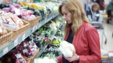 Genç kadın bakkal, süpermarkette alışveriş kadın Gıda seçimi. 4k, arka plan bulanıklık