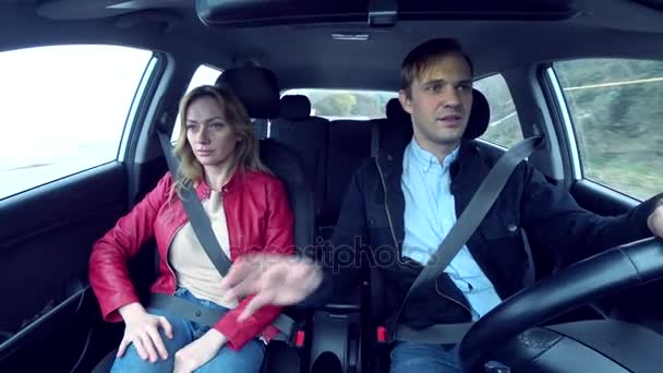 Hombre y mujer viajan en un coche en un área desconocida, abrochados con cinturones de seguridad, 4k — Vídeo de stock