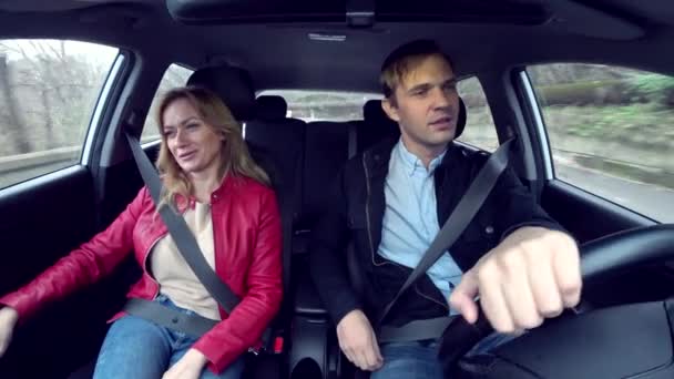 Man and woman ride in a car in an unfamiliar area, fastened with seat belts, 4k — Stock Video