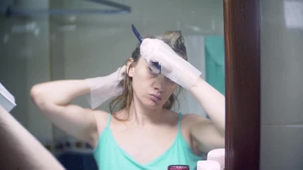 Женщина красит волосы дома. Раскрашиваю волосы крупным планом. 4k, slow motion — стоковое видео