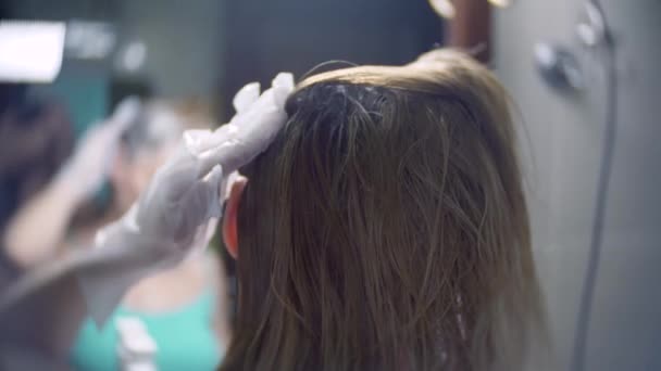 La mujer se tiñe el pelo en casa. Colorear el pelo de cerca. 4k, cámara lenta — Vídeo de stock