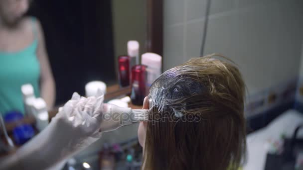 Женщина красит волосы дома. Раскрашиваю волосы крупным планом. 4k, slow motion — стоковое видео