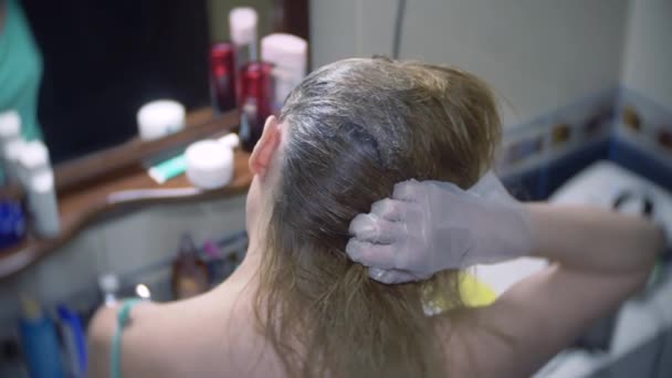 La mujer se tiñe el pelo en casa. Colorear el pelo de cerca. 4k, cámara lenta — Vídeos de Stock