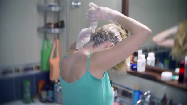 La mujer se tiñe el pelo en casa. Colorear el pelo de cerca. 4k, cámara lenta — Vídeos de Stock